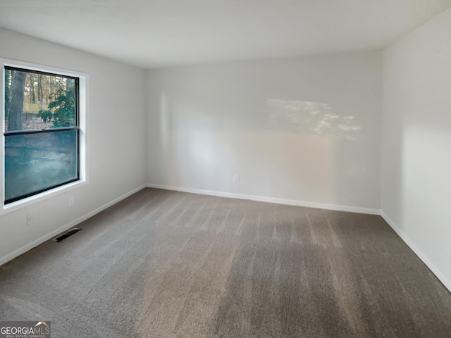 unfurnished room featuring visible vents, baseboards, and carpet flooring