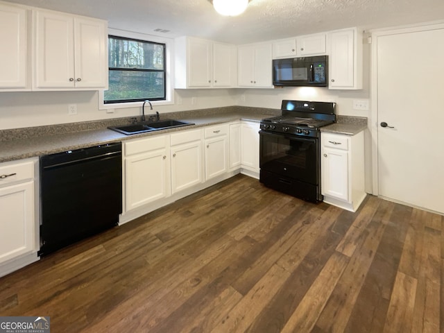 kitchen with dark wood finished floors, white cabinets, black appliances, and a sink