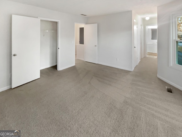 unfurnished bedroom featuring carpet flooring, baseboards, and visible vents