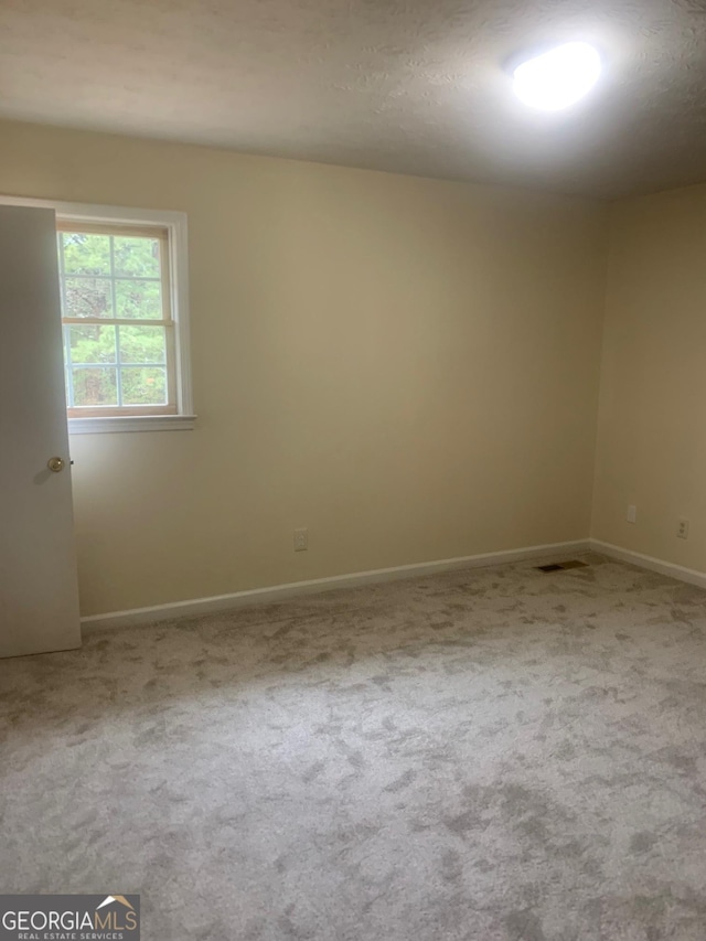 unfurnished room featuring carpet flooring and baseboards