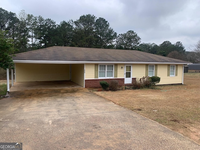 ranch-style home featuring an attached carport, brick siding, and driveway