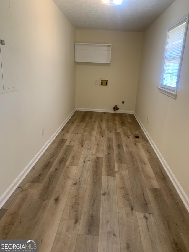 laundry area featuring light wood finished floors, baseboards, gas dryer hookup, laundry area, and hookup for a washing machine