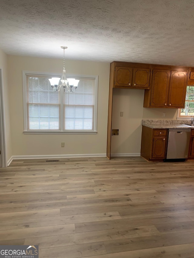 kitchen featuring visible vents, light wood-type flooring, brown cabinets, a textured ceiling, and stainless steel dishwasher