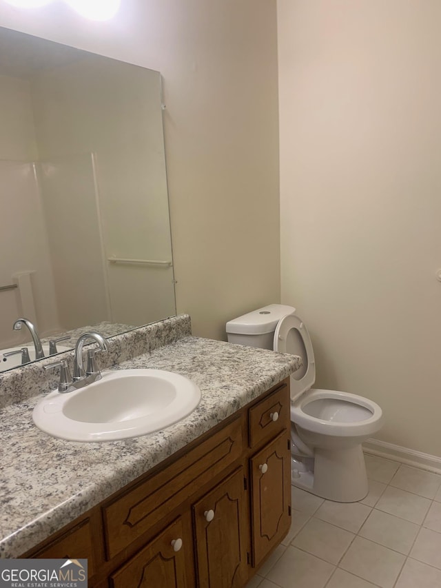 bathroom featuring tile patterned floors, baseboards, toilet, and vanity