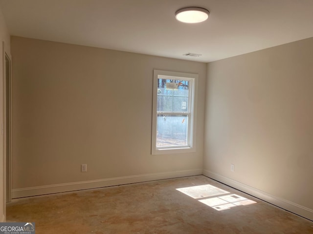 spare room featuring visible vents, baseboards, and concrete floors