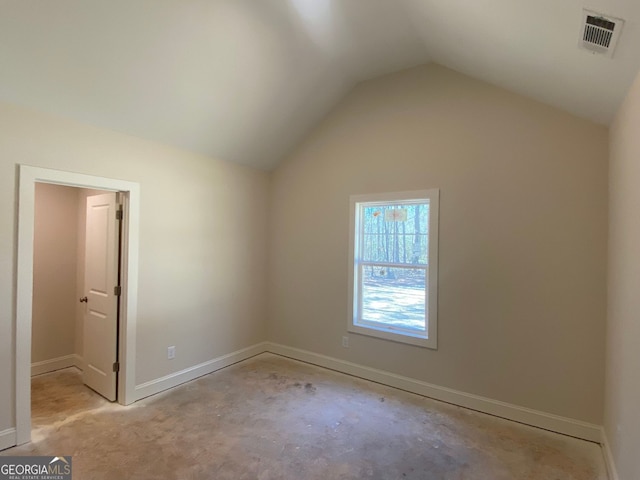 bonus room featuring visible vents, baseboards, unfinished concrete flooring, and lofted ceiling