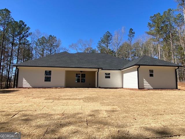 rear view of house featuring a shingled roof