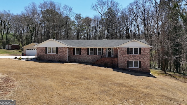 ranch-style home featuring a front lawn, a garage, and brick siding