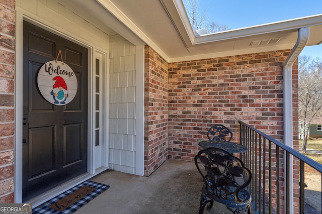 view of exterior entry featuring brick siding