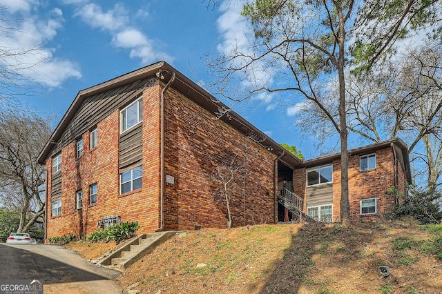 view of home's exterior featuring brick siding and stairs