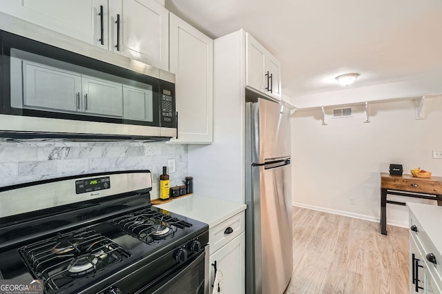 kitchen featuring light wood finished floors, visible vents, backsplash, light countertops, and appliances with stainless steel finishes