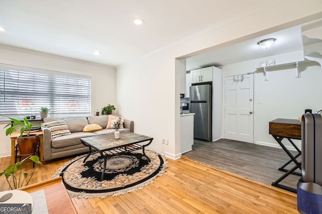 living area featuring recessed lighting, light wood-type flooring, crown molding, and baseboards