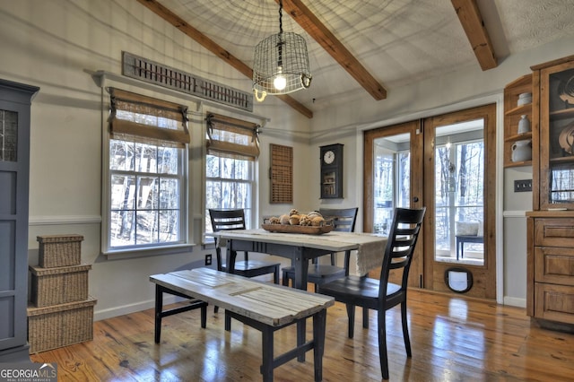 dining space with french doors, vaulted ceiling with beams, baseboards, and wood finished floors