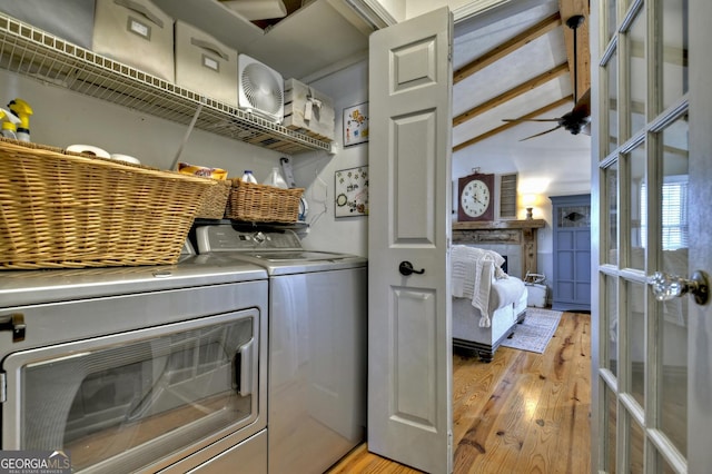 laundry area with washing machine and clothes dryer, laundry area, french doors, and light wood-type flooring