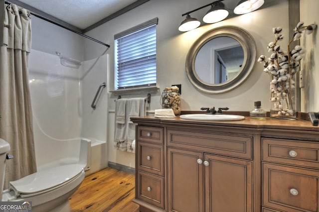 bathroom with toilet, vanity, a shower with curtain, and wood finished floors