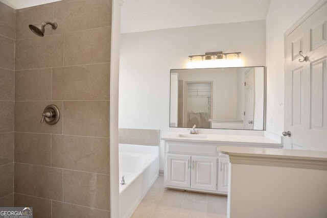 bathroom featuring tile patterned flooring, a garden tub, a tile shower, a closet, and vanity