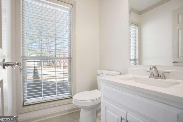 bathroom with tile patterned flooring, toilet, vanity, and ornamental molding