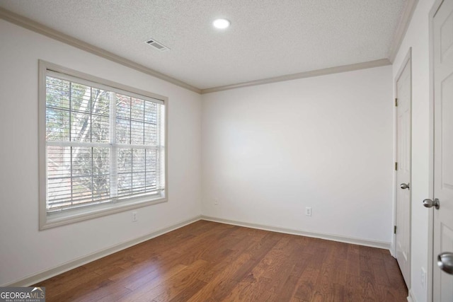 unfurnished bedroom featuring wood finished floors, baseboards, visible vents, a textured ceiling, and crown molding