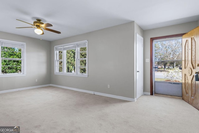 entryway with light carpet, ceiling fan, and baseboards