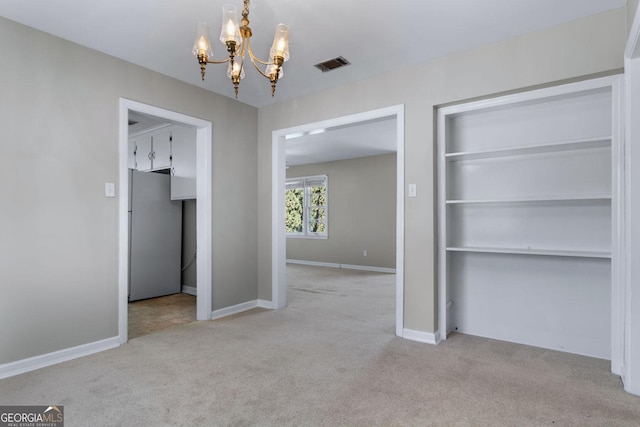 unfurnished dining area with a notable chandelier, carpet, visible vents, and baseboards