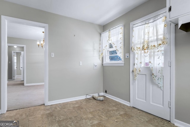 entryway featuring baseboards and a chandelier