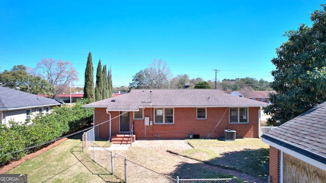 rear view of house with a lawn, brick siding, and fence private yard