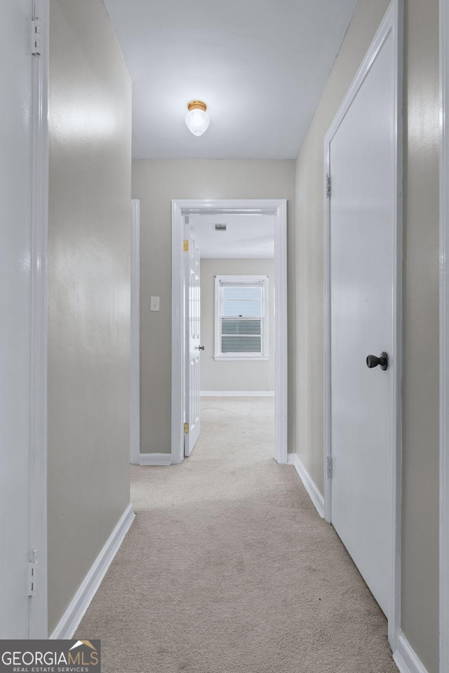 hall featuring baseboards and carpet floors