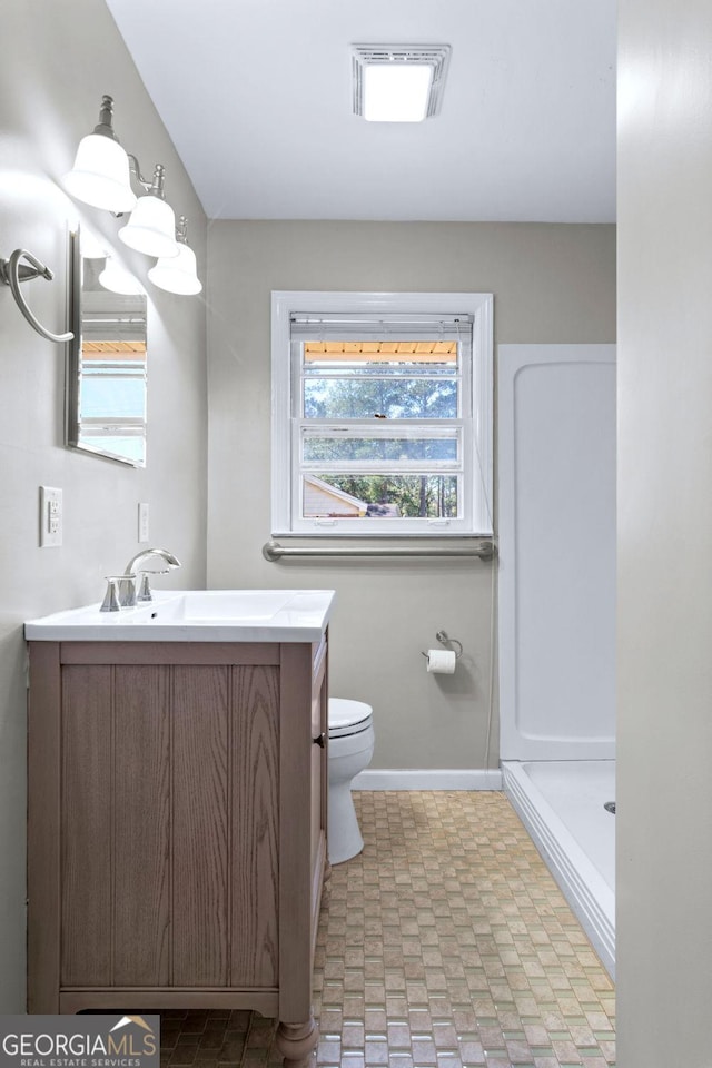 bathroom featuring visible vents, baseboards, toilet, vanity, and a shower