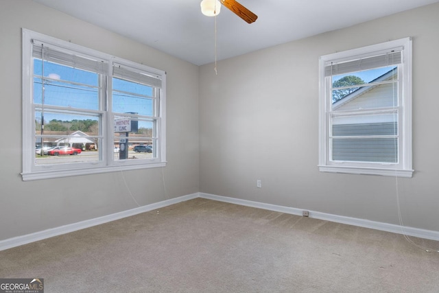 unfurnished room featuring carpet flooring, ceiling fan, and baseboards