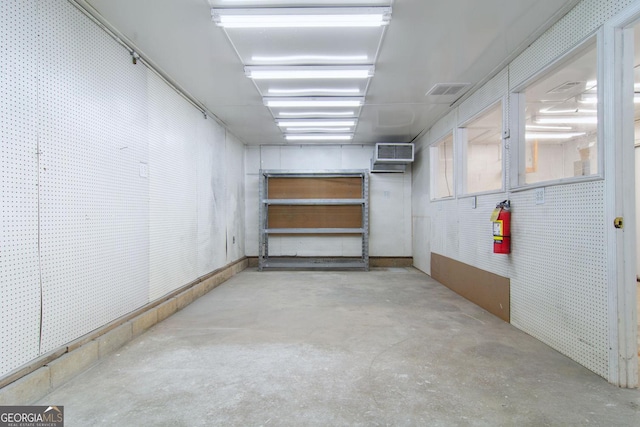 basement featuring an AC wall unit and a garage