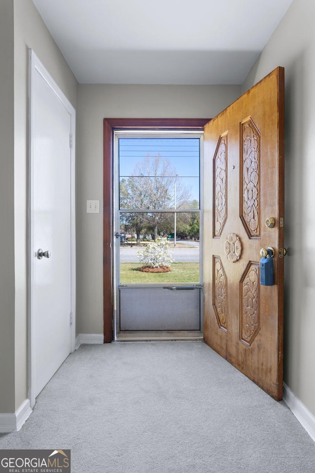 entryway featuring baseboards and carpet