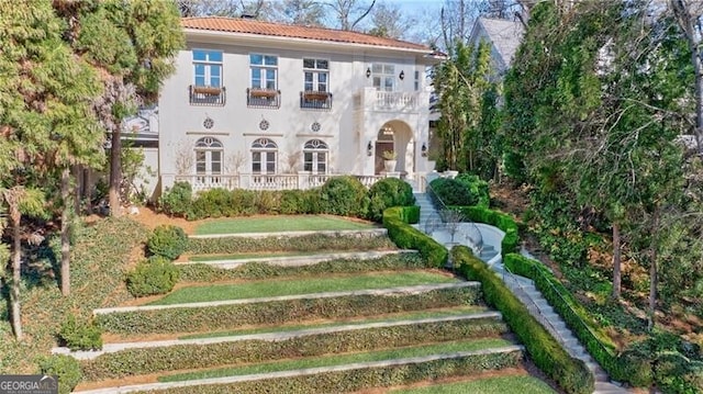 view of front of property with stucco siding and a balcony