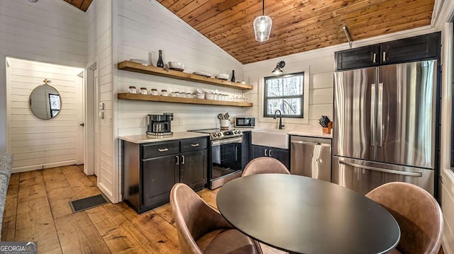 kitchen featuring visible vents, wood ceiling, lofted ceiling, appliances with stainless steel finishes, and a sink