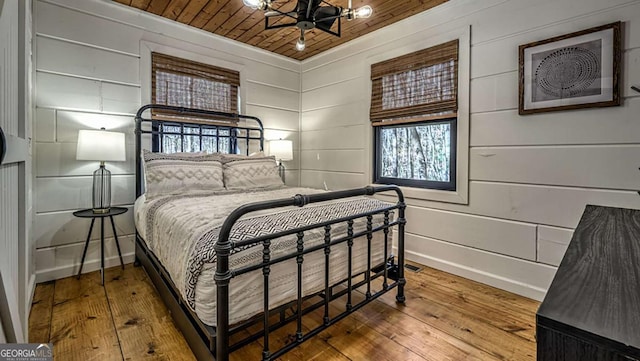 bedroom with wooden ceiling, baseboards, and hardwood / wood-style flooring