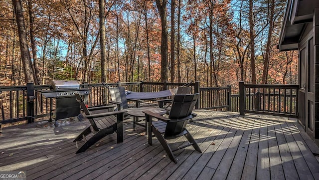 wooden deck featuring area for grilling and outdoor dining area