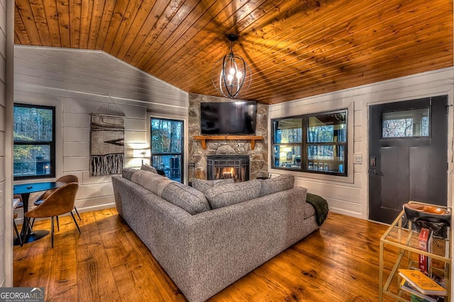 living area with a stone fireplace, wood ceiling, vaulted ceiling, and hardwood / wood-style flooring