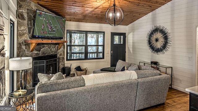 living area with hardwood / wood-style floors, wooden ceiling, a fireplace, and vaulted ceiling