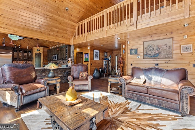 living room featuring wood-type flooring, high vaulted ceiling, wooden ceiling, and wood walls