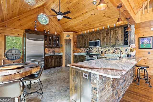 kitchen with a sink, appliances with stainless steel finishes, wood walls, and wood ceiling