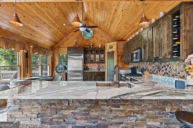 kitchen featuring a sink, tasteful backsplash, stainless steel appliances, lofted ceiling, and wood ceiling