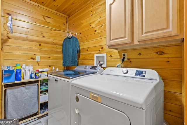 laundry room featuring cabinet space, wooden walls, wooden ceiling, and washing machine and clothes dryer