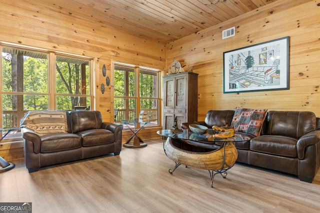 living room featuring wood finished floors, wood ceiling, visible vents, and wood walls