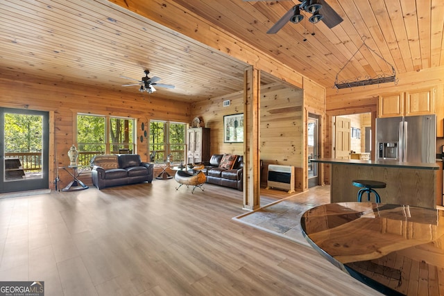 living room featuring wood walls, wood ceiling, light wood-style floors, and ceiling fan