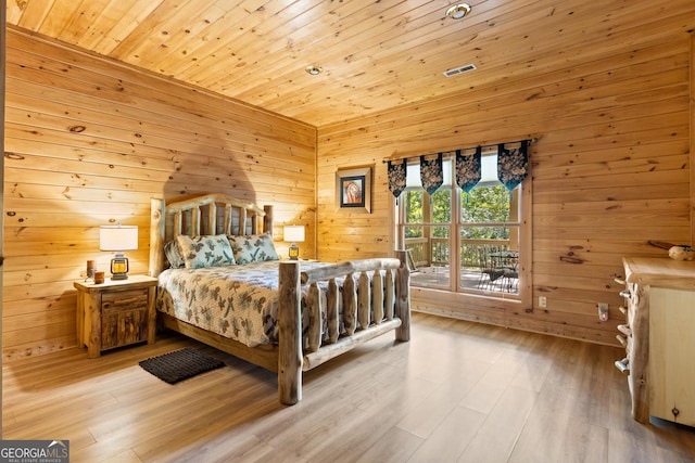 bedroom with wooden walls, wooden ceiling, light wood-style floors, and access to outside