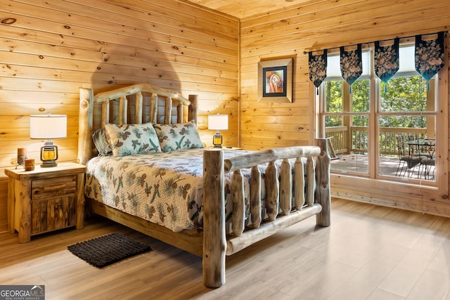 bedroom featuring wood finished floors and wood walls