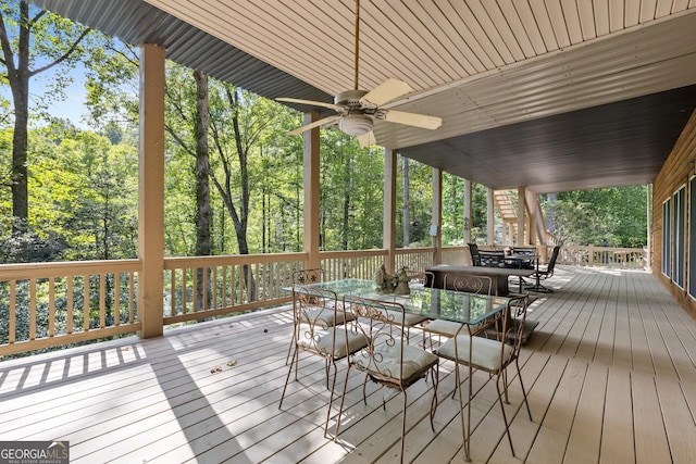 deck with outdoor dining space and a ceiling fan