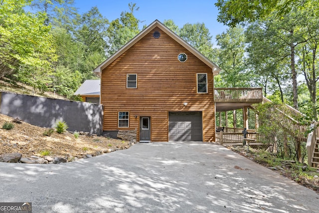 view of home's exterior featuring stairway, a garage, driveway, and a wooden deck