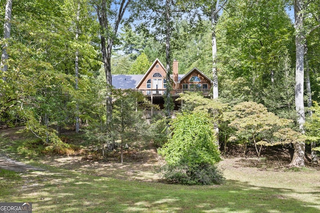 view of front of home featuring a front lawn and a chimney