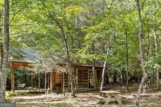 exterior space with an outbuilding and a view of trees