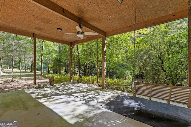 view of patio with a ceiling fan and a forest view